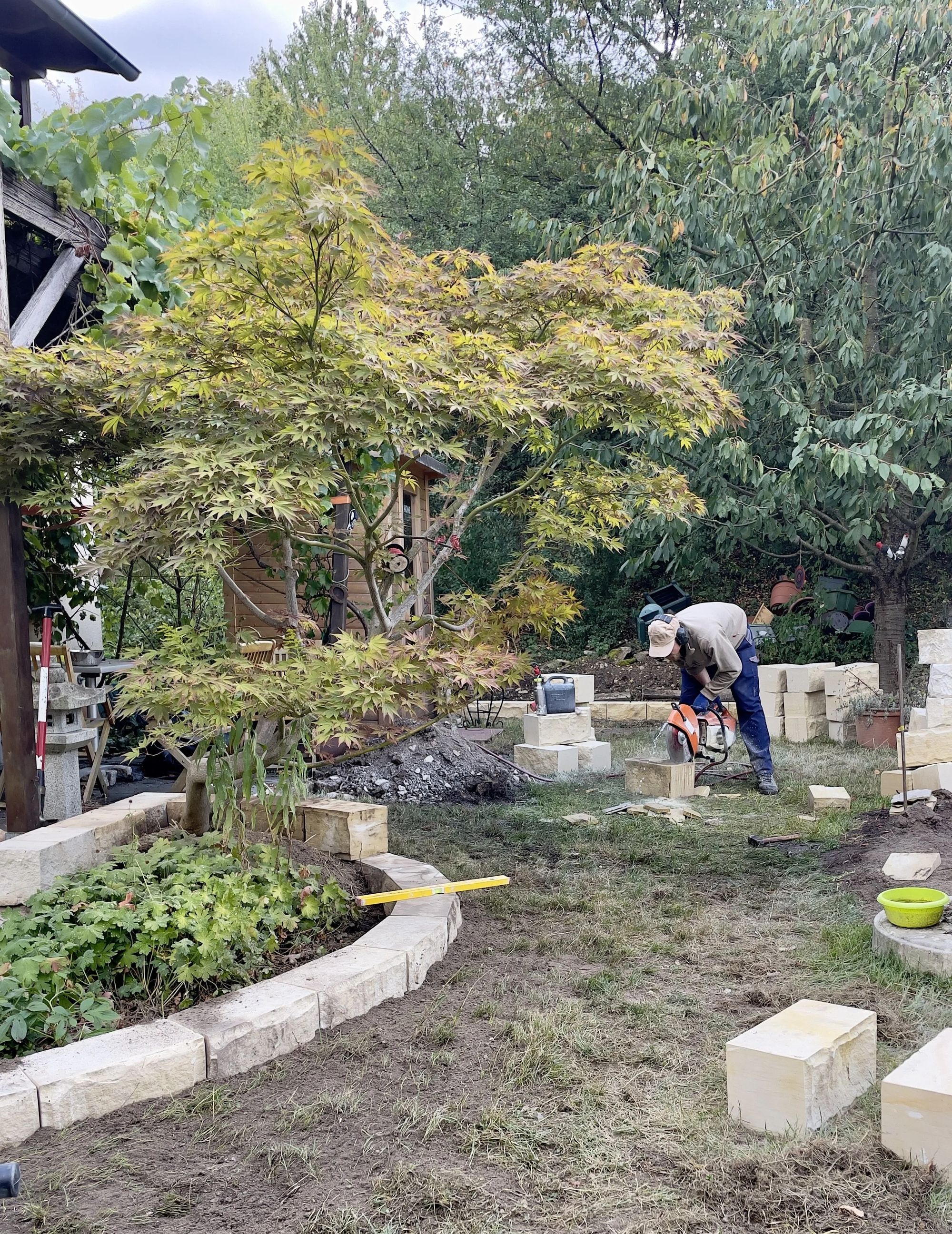 Gärtner beim Bau einer Beeteinfassung aus Sandstein